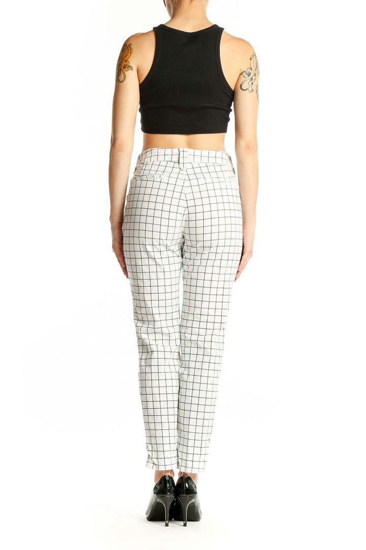 Side view of model wearing NYDJ white grid pattern denim pants with black crop top