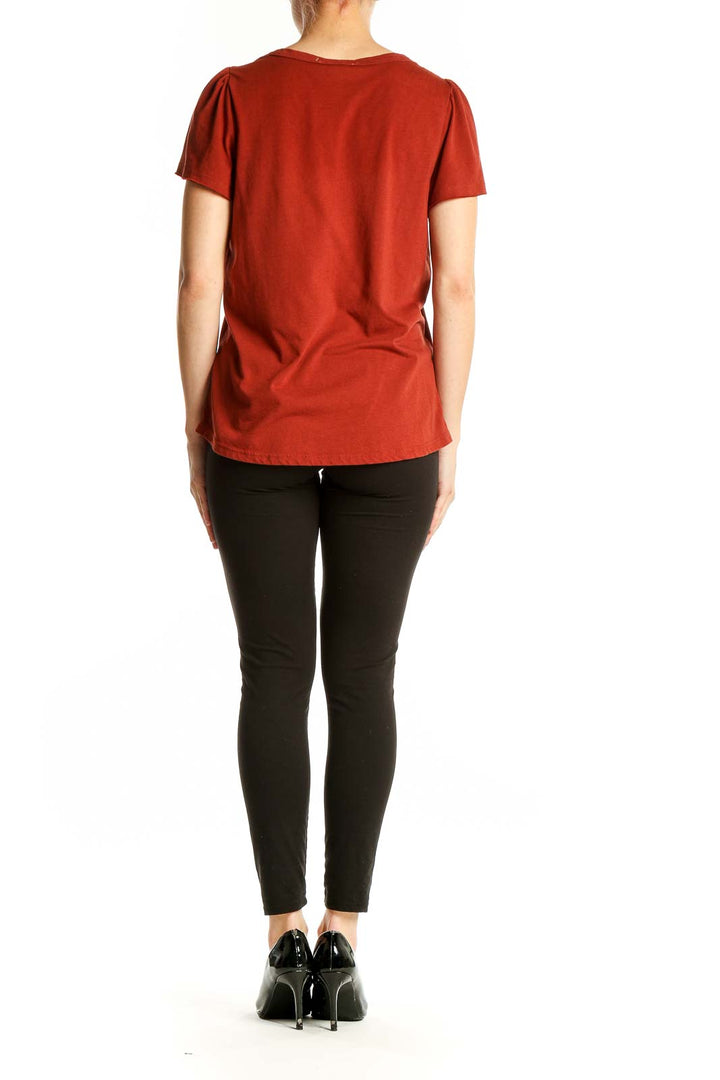 Back view of rust-colored Philosophy flutter sleeve top on model