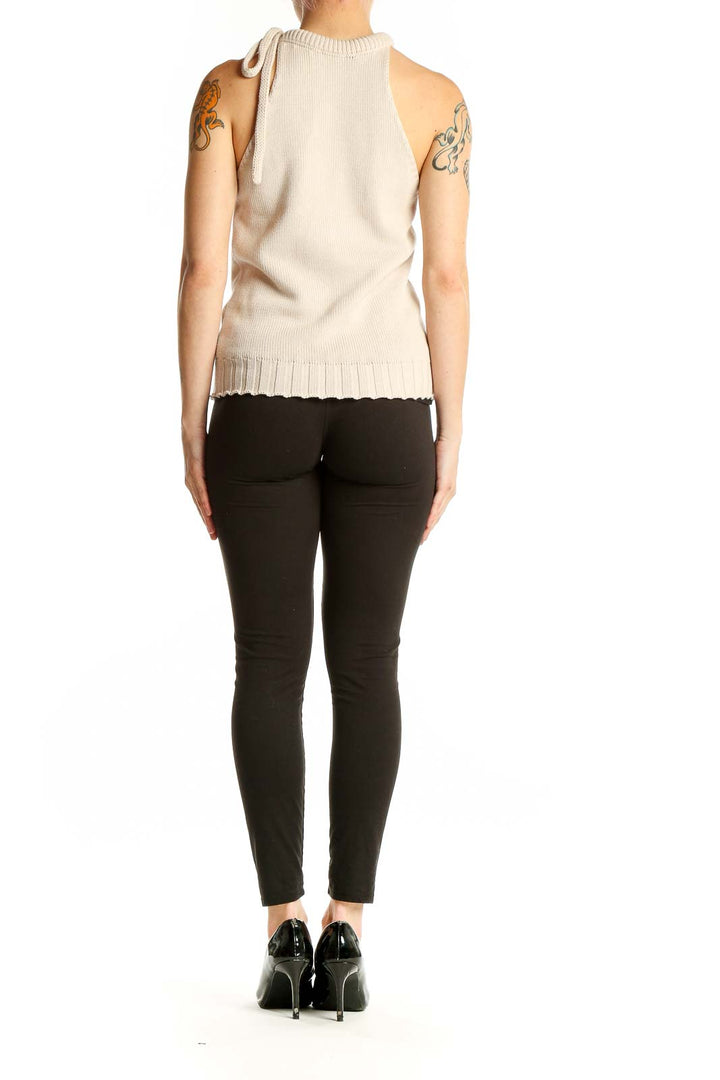 Side view of G. Label beige sleeveless knit top showing ribbed texture and pleated hem