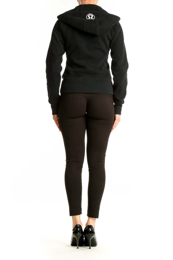 Back view of black Lululemon zip-up hooded athletic jacket on model