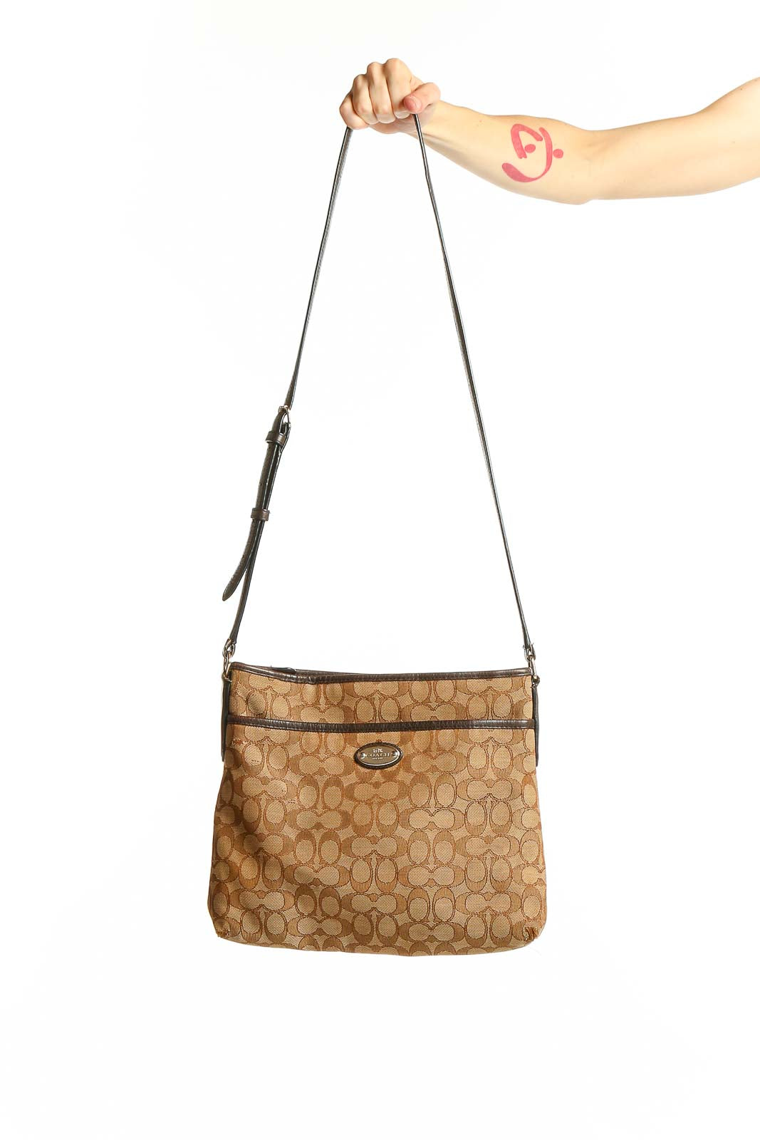 Front view of tan Coach Signature Canvas Crossbody Bag with monogram pattern