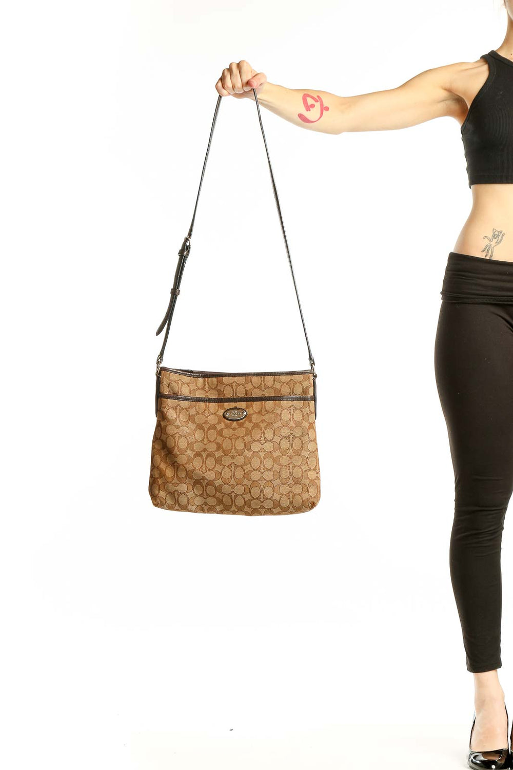 Front view of tan Coach Signature Canvas Crossbody Bag with monogram pattern