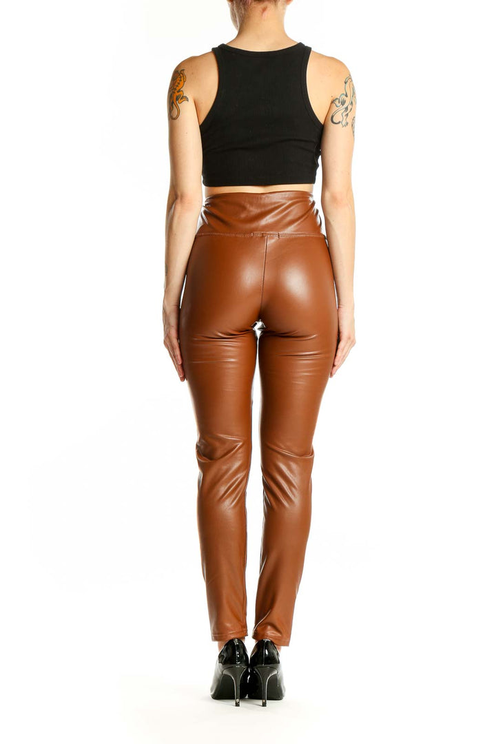 Side view of woman wearing Bagatelle brown high-waisted faux leather leggings with black top
