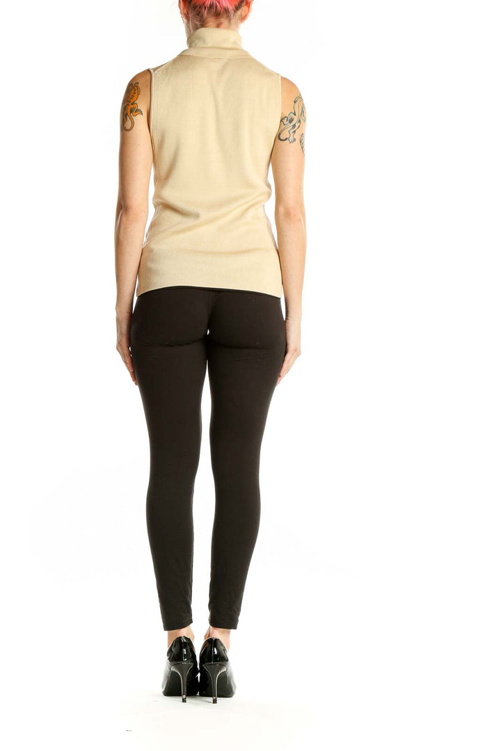 Side view of Ann Taylor cream sleeveless turtleneck knit top on model