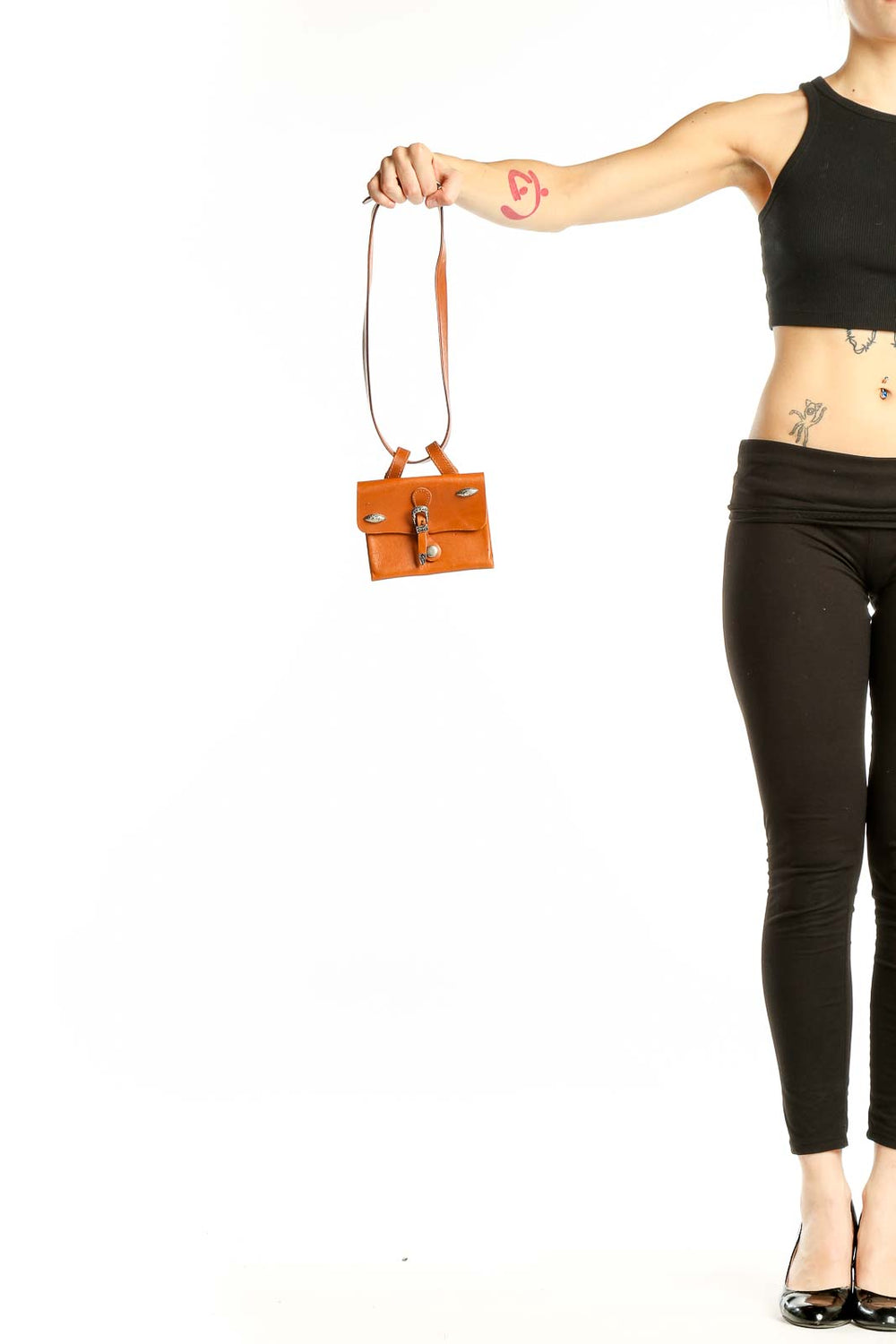 Orange mini leather clutch bag from SilkRoll held by hand