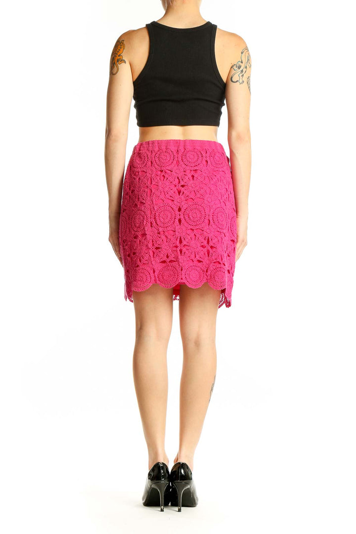 Side view of model wearing Caroline Constas hot pink crochet lace pencil skirt with black top