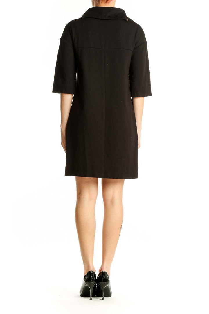 Side view of Komarov black shift dress showing zippered pocket detail
