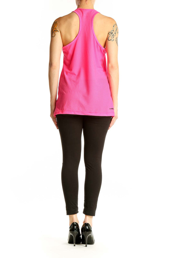 Side view of pink Head racerback tank top on model with black pants