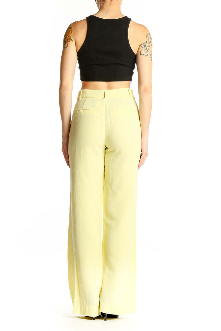 Side view of Zara yellow wide-leg trousers on model with black crop top