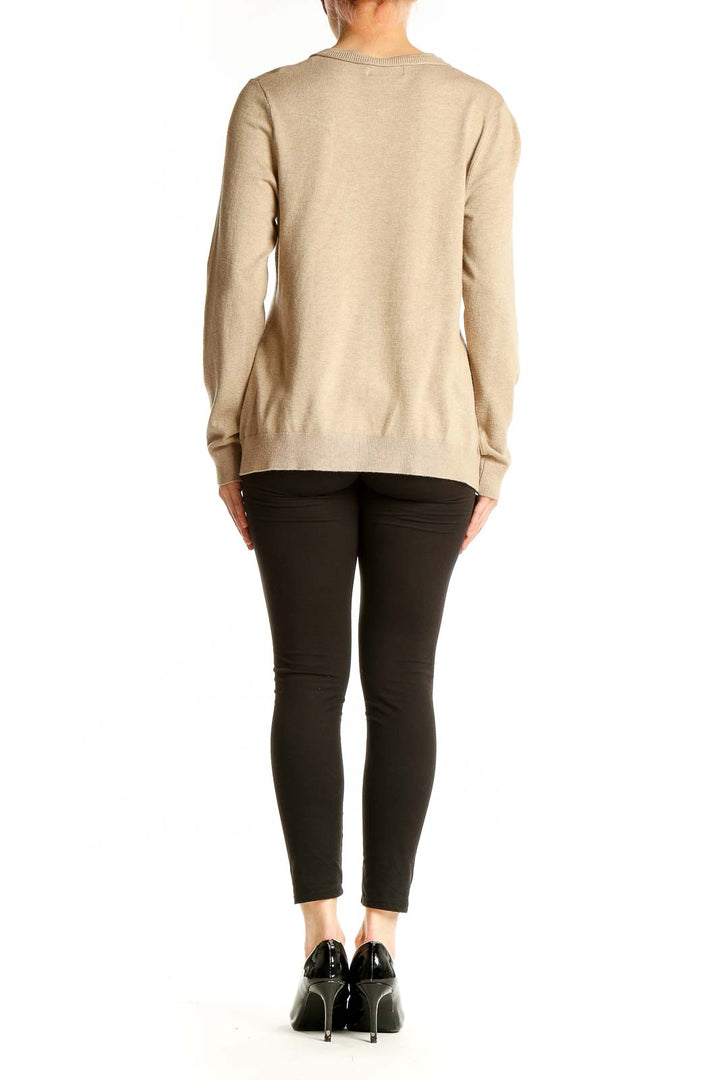 Back view of beige Calvin Klein cardigan worn with black pants