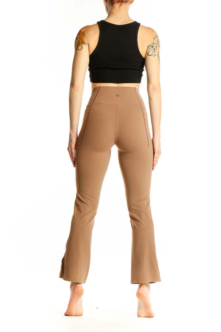 Side view of model wearing tan high-waisted flare yoga pants from Athleta