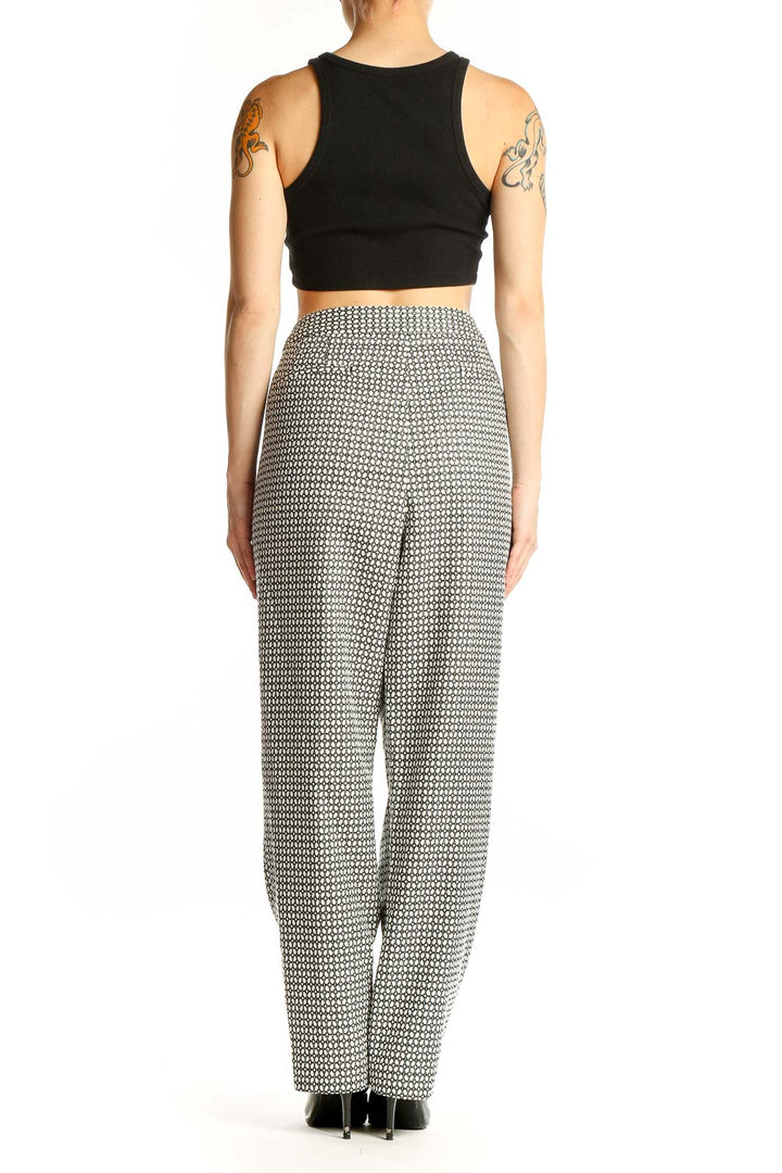 Side view of model wearing Talbots black and white geometric print wide-leg pants with black top