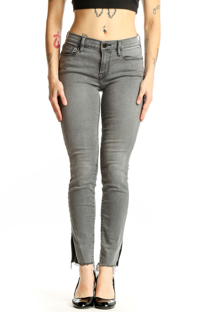 Front view of gray FRAME Denim skinny jeans with ankle slits
