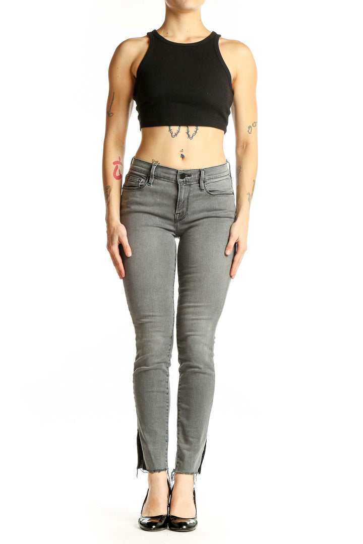 Front view of gray FRAME Denim skinny jeans with ankle slits