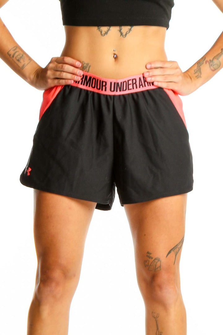Front view of black Under Armour athletic shorts with pink side panels and elastic waistband
