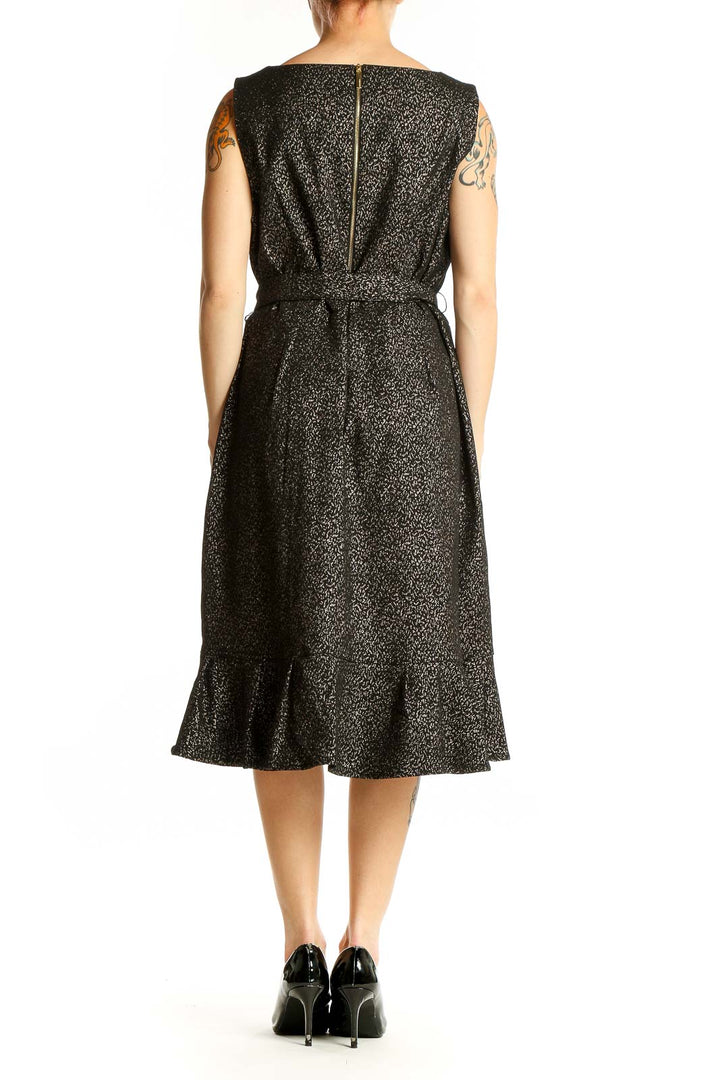 Back view of Calvin Klein black metallic ruffle wrap dress showing asymmetrical hem