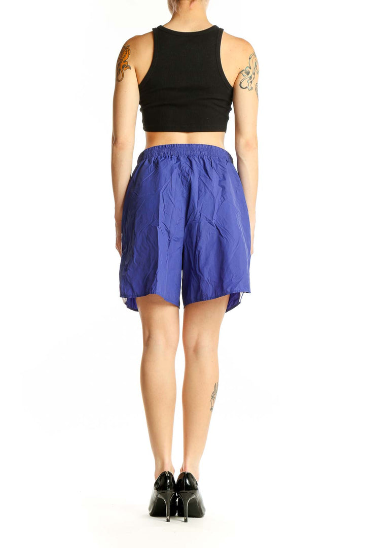 Side view of blue Rag & Bone nylon athletic shorts on model