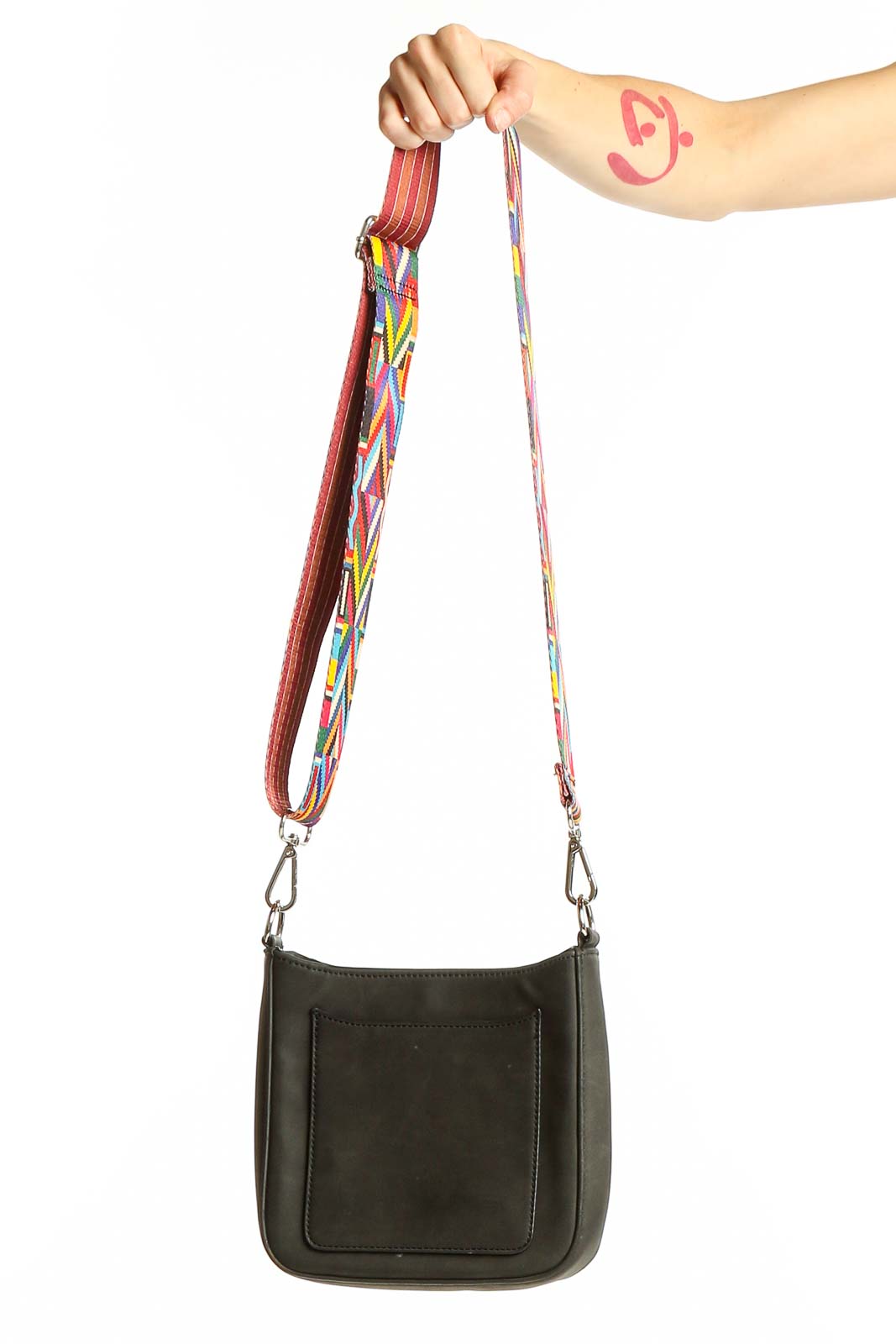 Front view of K.carroll black crossbody bag with colorful geometric strap