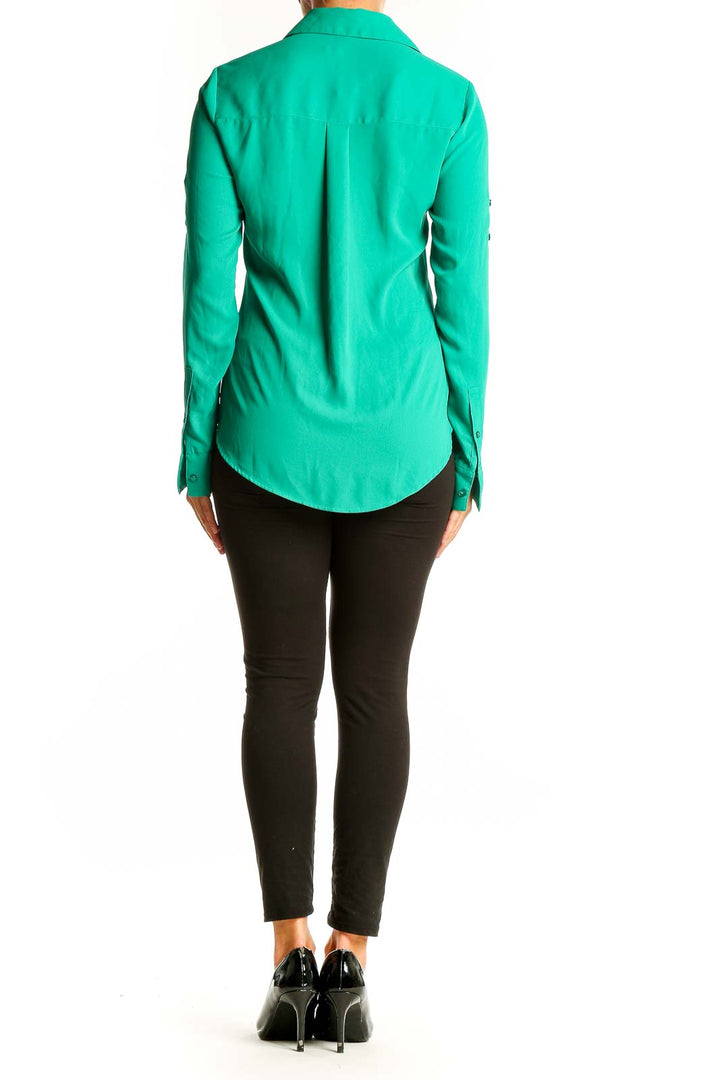 Side view of green Express button-down shirt on model with black pants