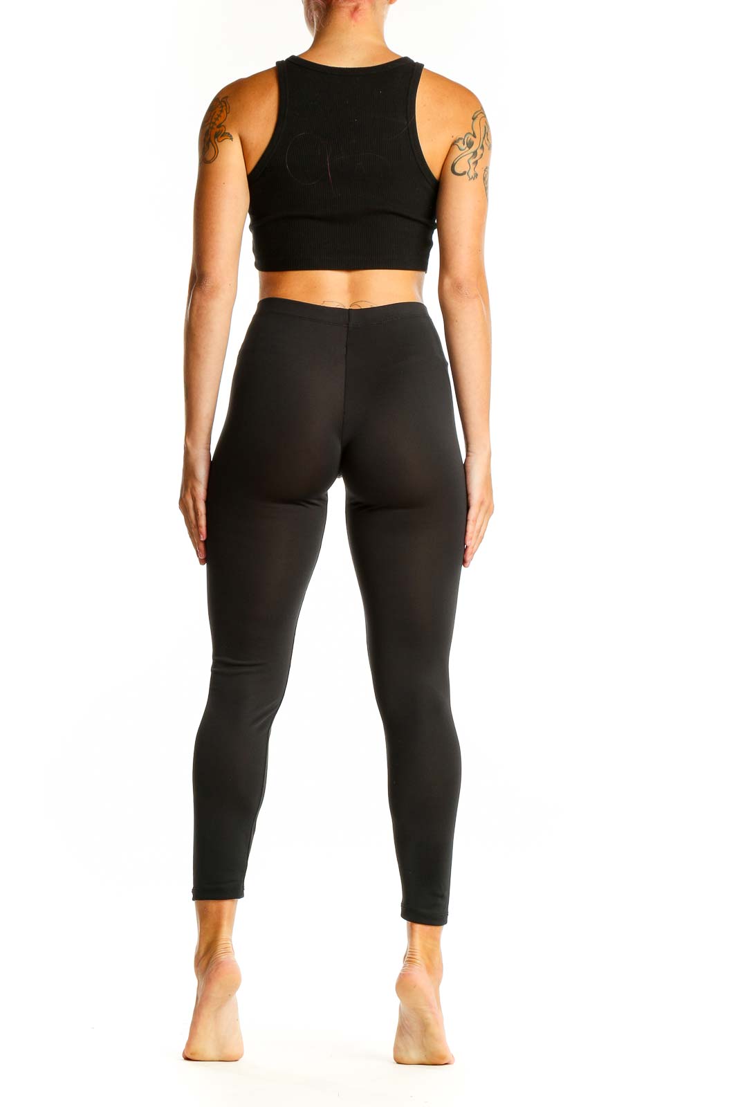 Side view of woman wearing black Adidas high-waisted leggings and crop top