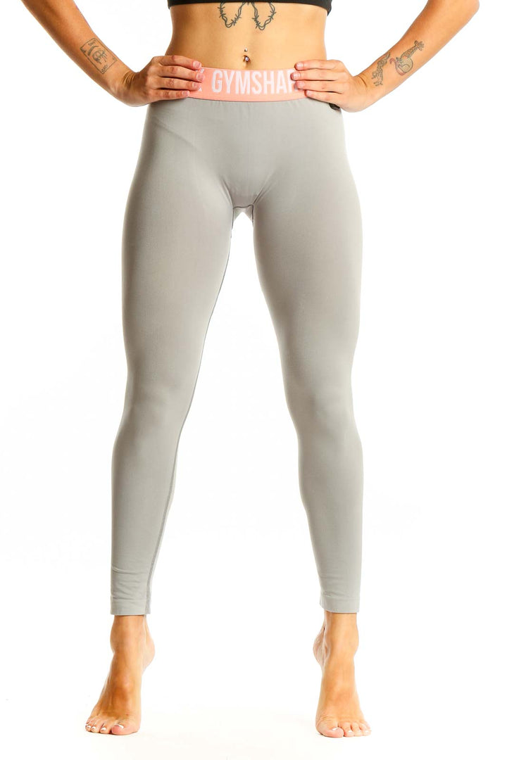 Front view of Gymshark gray high-waisted leggings with pink waistband