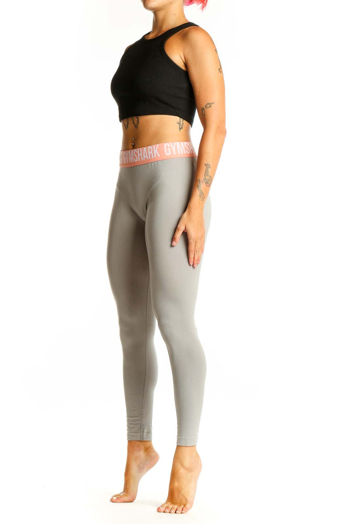 Front view of Gymshark gray high-waisted leggings with pink waistband