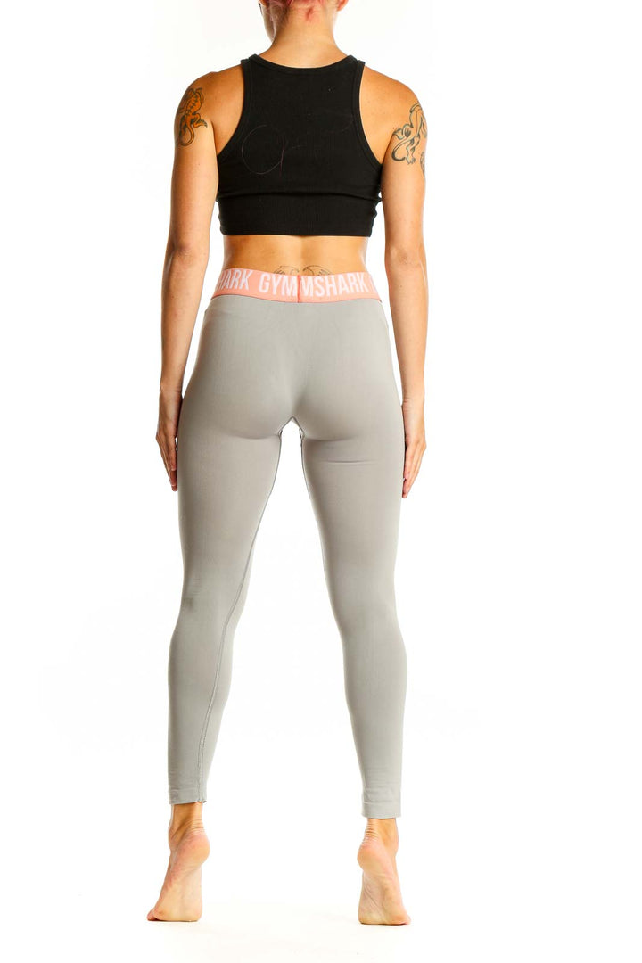 Side view of woman wearing Gymshark gray leggings and black crop top