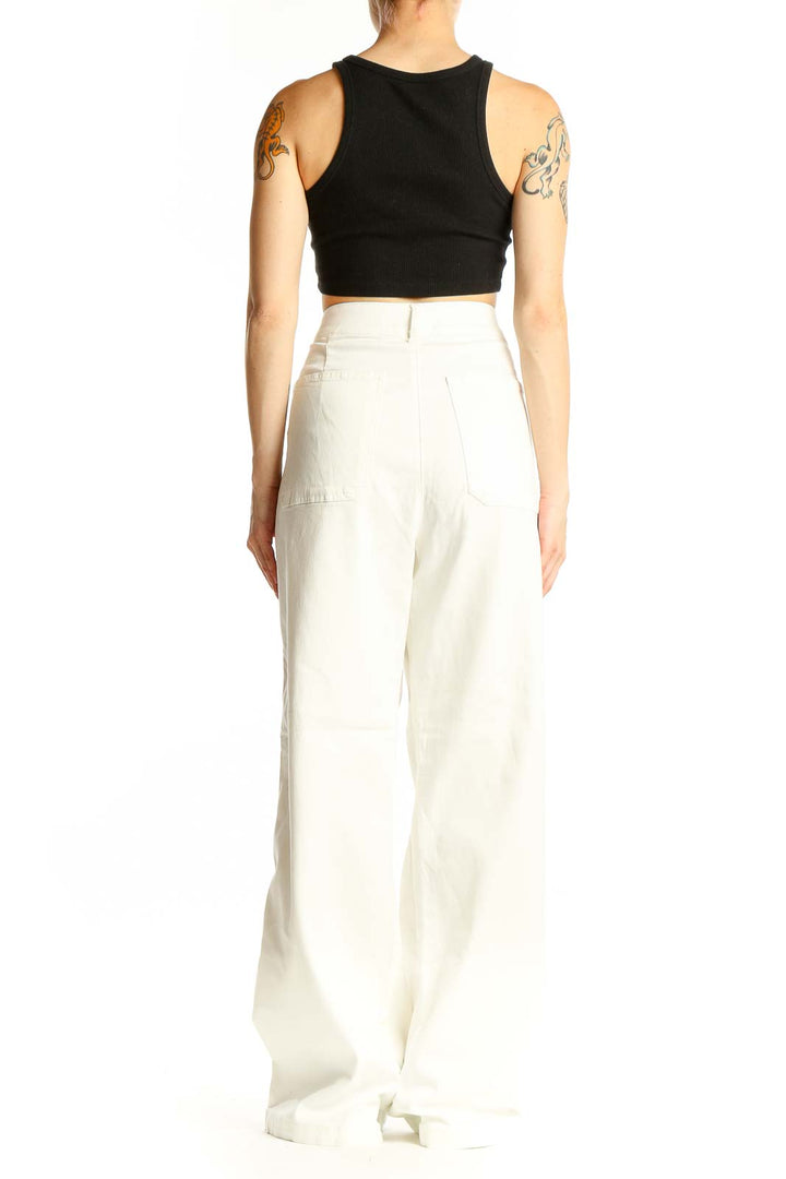 Side view of model wearing white high-waisted wide-leg denim pants