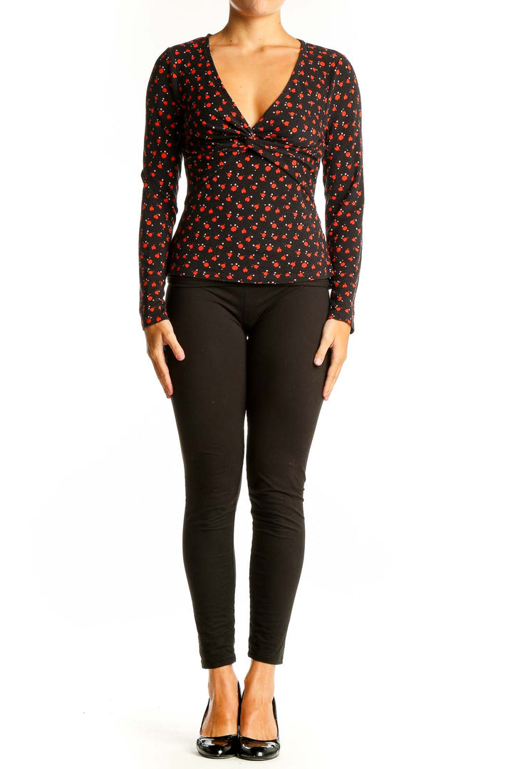 Front view of Boden black V-neck top with red cherry blossom print and twist detail
