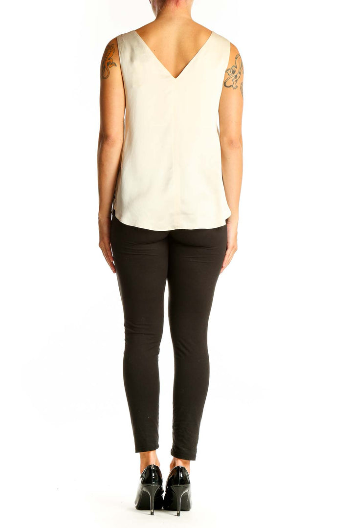 Side view of model wearing Autograph ivory silk sleeveless top with black pants