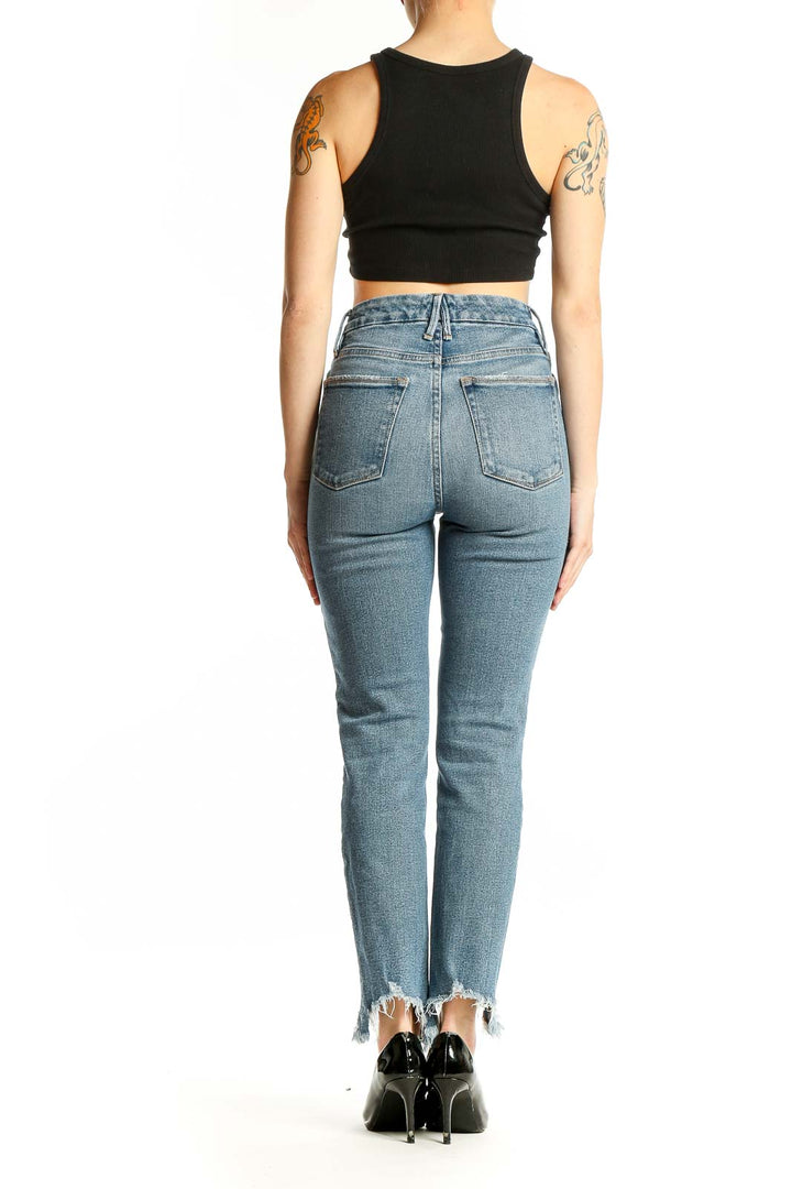 Back view of Good American light blue high-rise skinny jeans showing fit and distressed hem detail