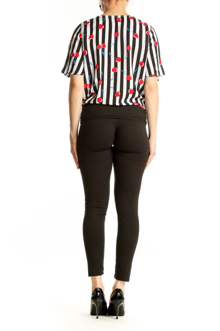 Side view of model wearing Cynthia Rowley black and white striped top with cherry print