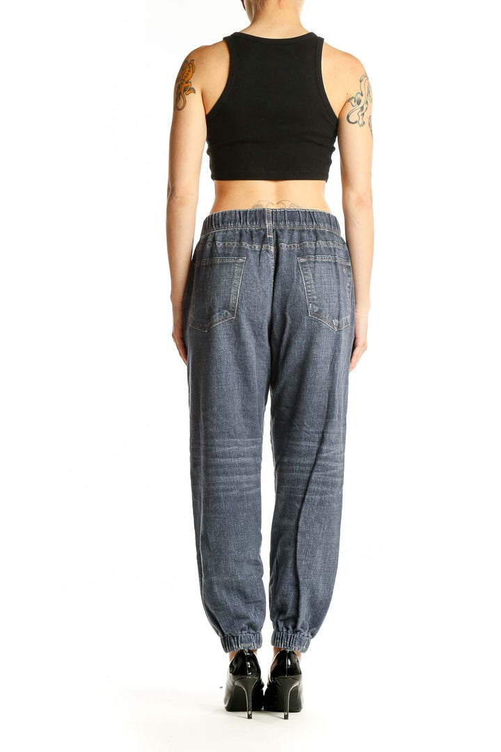 Side view of woman wearing Rag & Bone blue denim jogger pants with black top