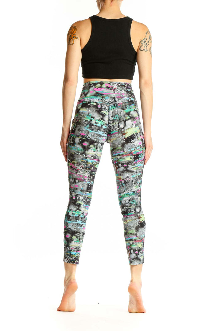 Side view of woman wearing Lululemon multicolor abstract print activewear leggings with black crop top
