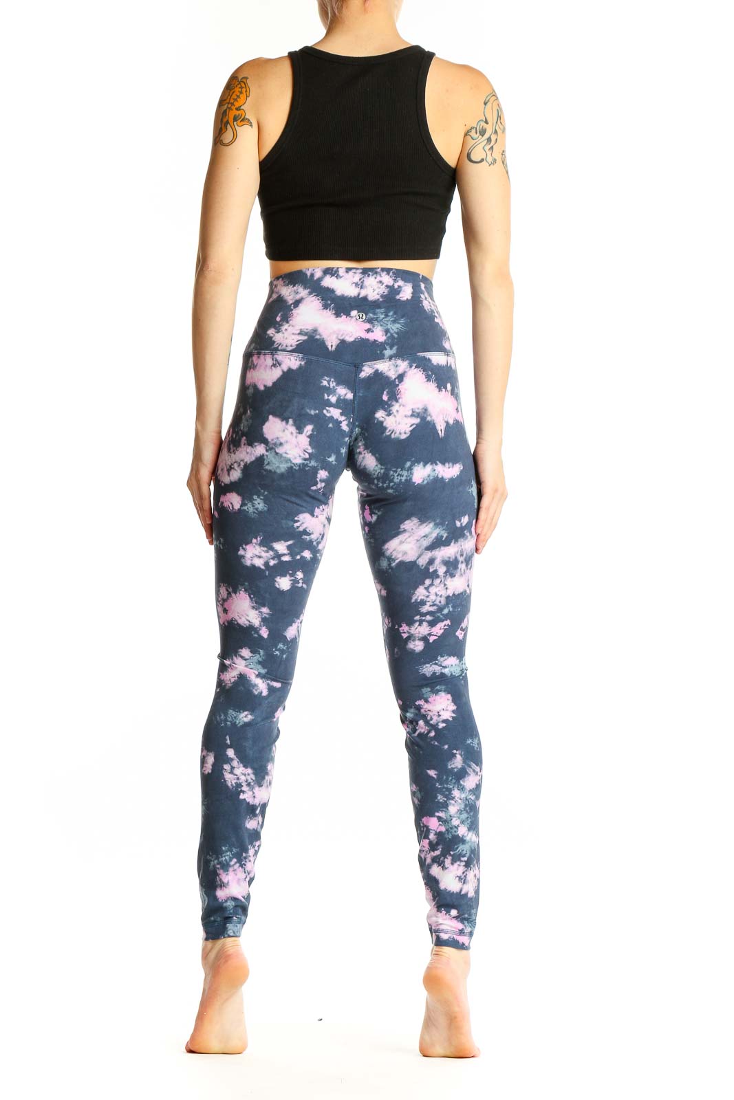 Side view of woman wearing Lululemon navy and pink tie-dye high-waisted activewear leggings