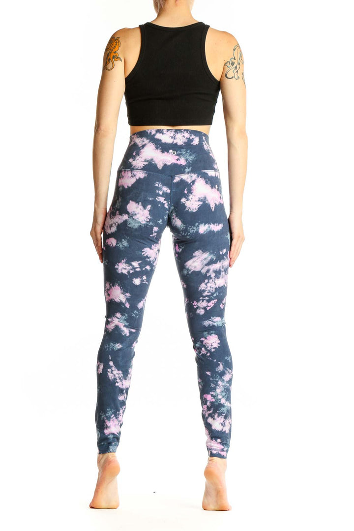 Side view of woman wearing Lululemon navy and pink tie-dye high-waisted activewear leggings