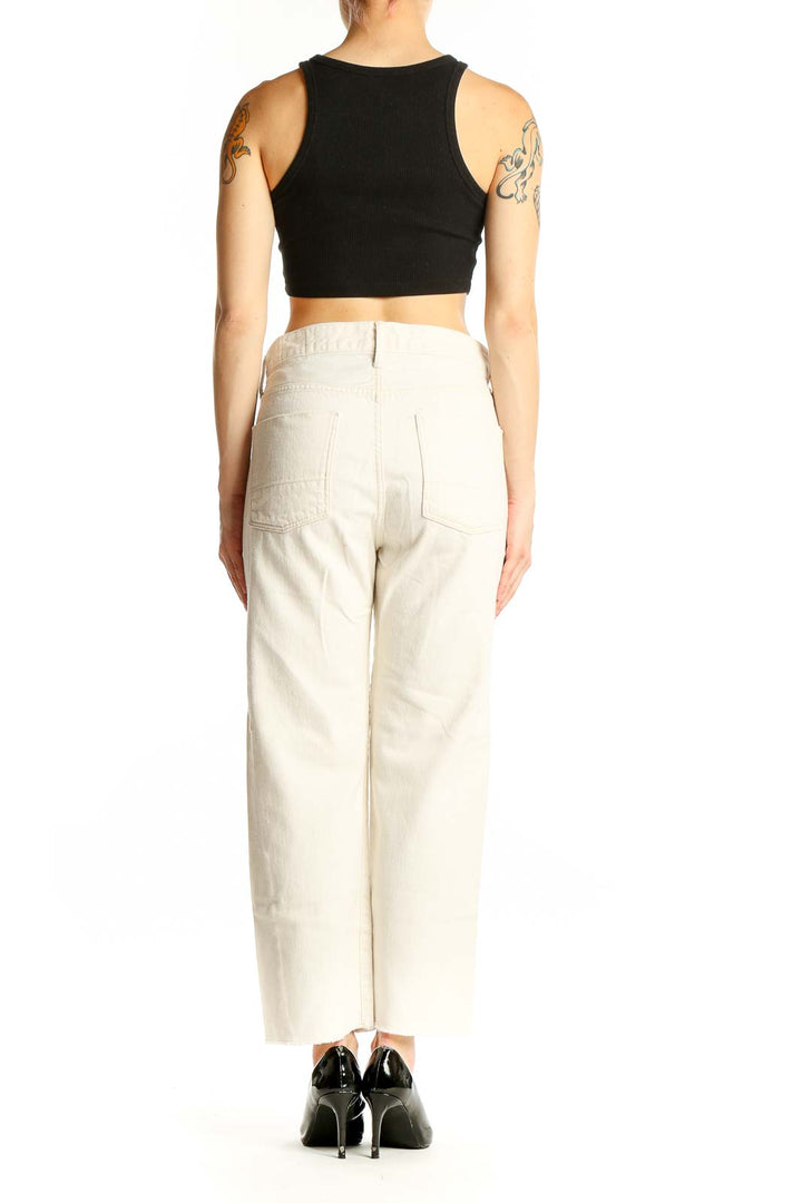 Side view of Vince cream cotton straight-leg jeans on model with black top