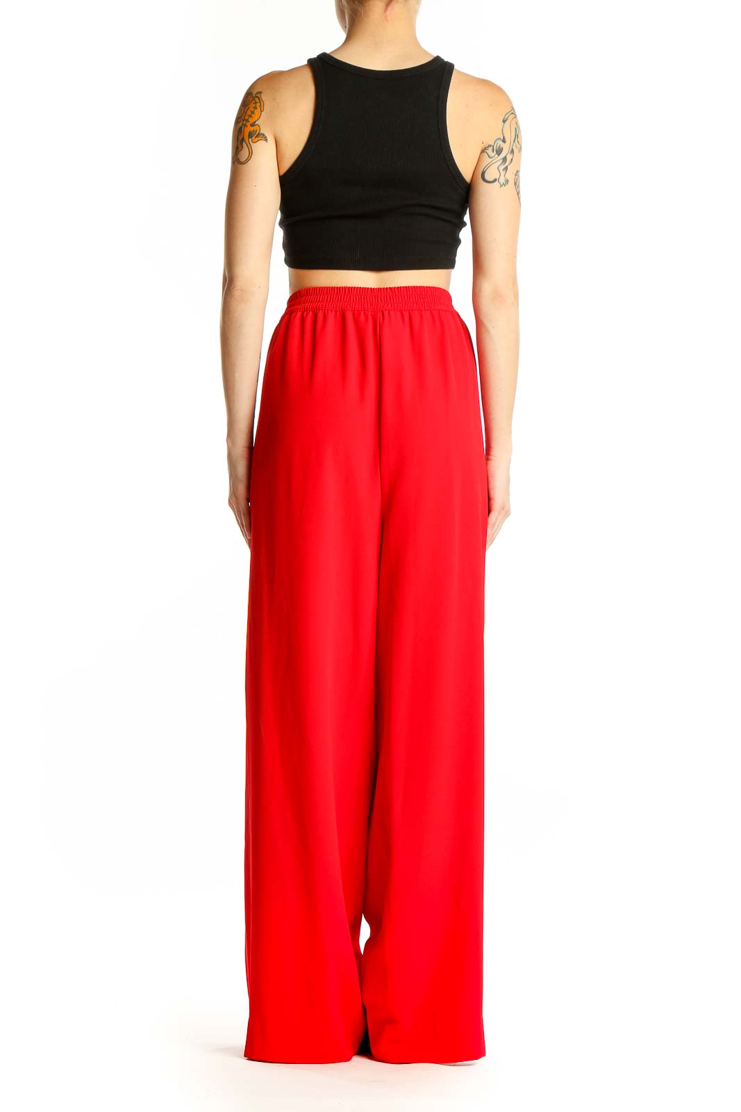 Side view of model wearing red DKNY wide-leg pants with black crop top