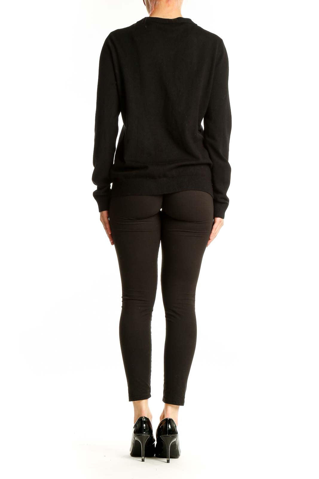 Side view of woman wearing black Calvin Klein cardigan with dark pants