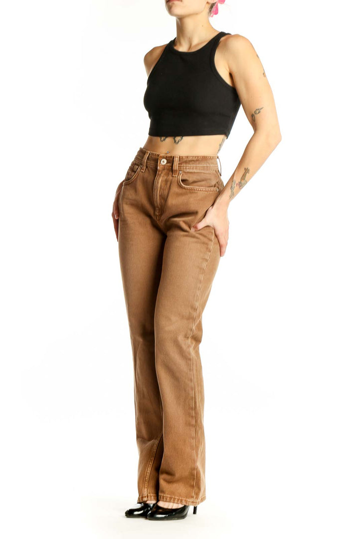 Front view of WE THE FREE tan high-waisted straight leg jeans on model
