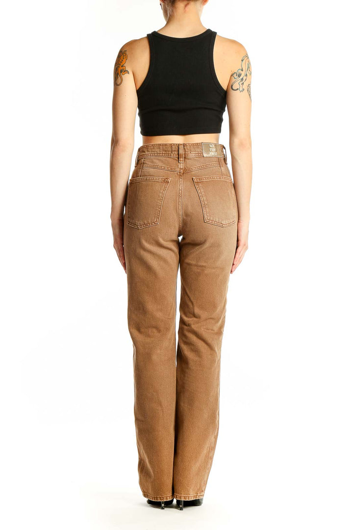 Side view of WE THE FREE tan high-waisted straight leg jeans on model with black crop top
