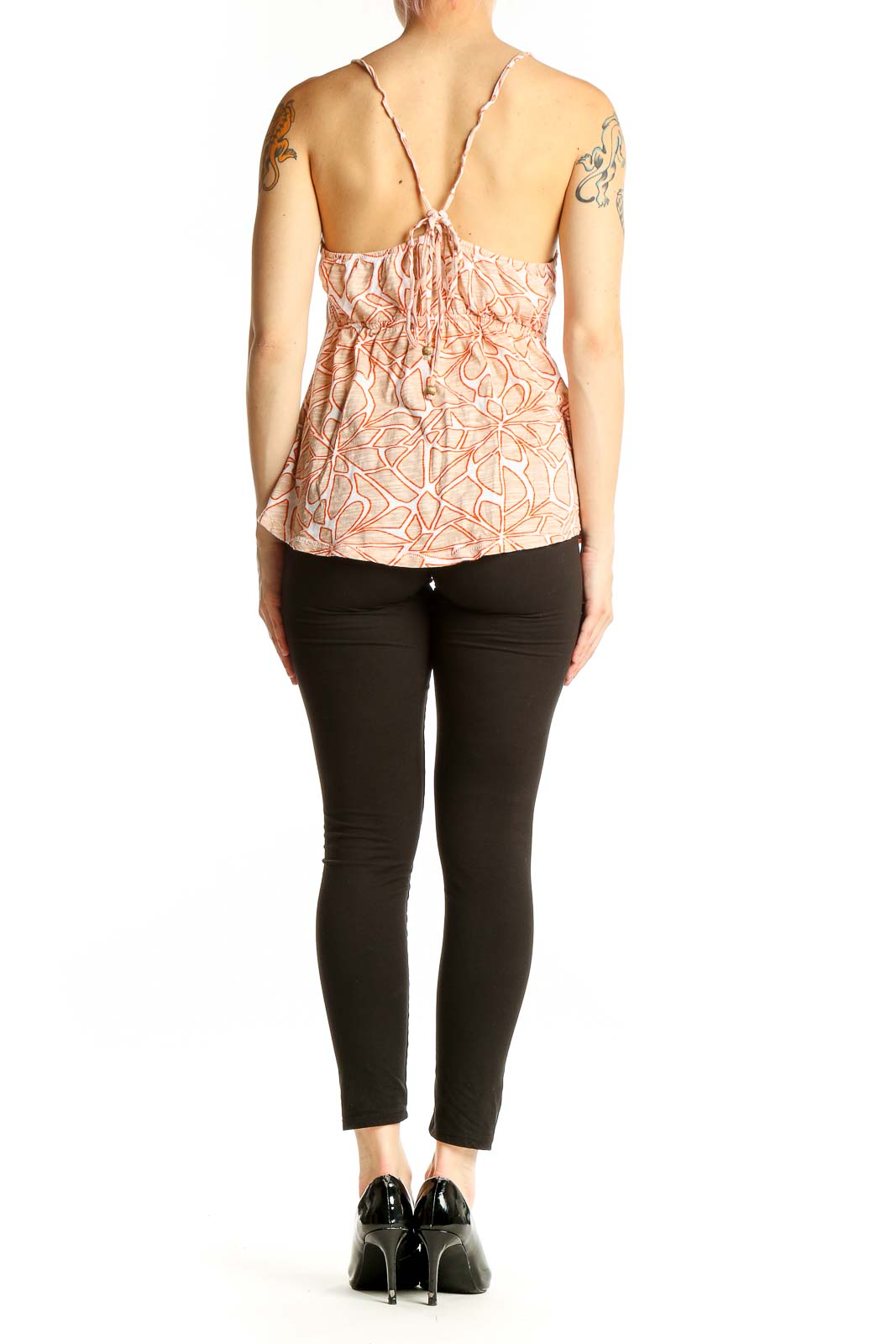Side view of model wearing Roxy peach floral print cami top with black pants