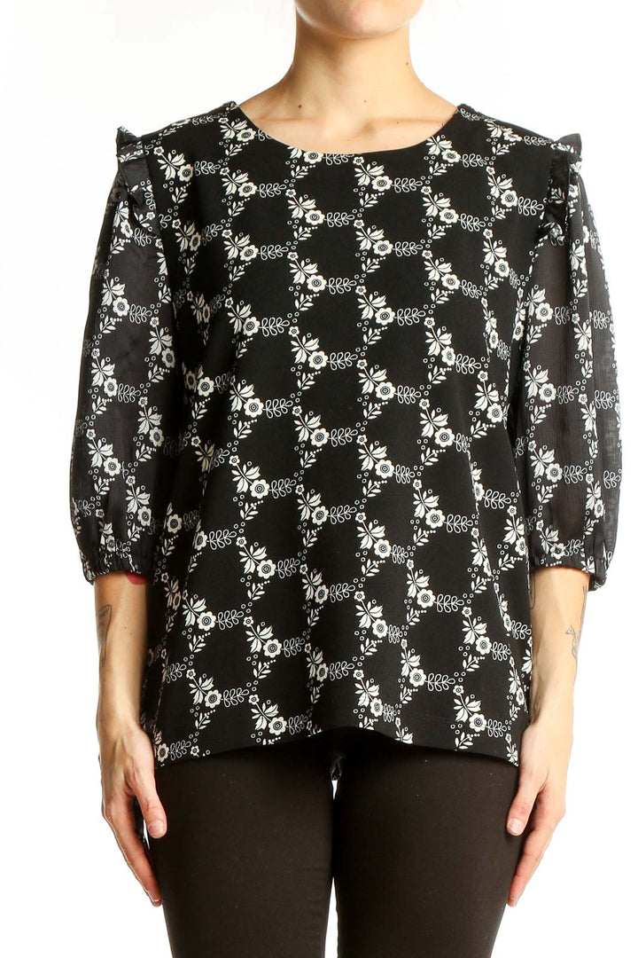 Front view of Ann Taylor black blouse with white floral print and puff sleeves