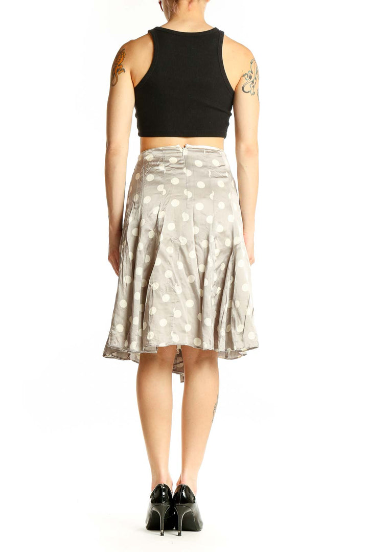 Side view of White House Black Market gray silk skirt with white polka dots, paired with black top