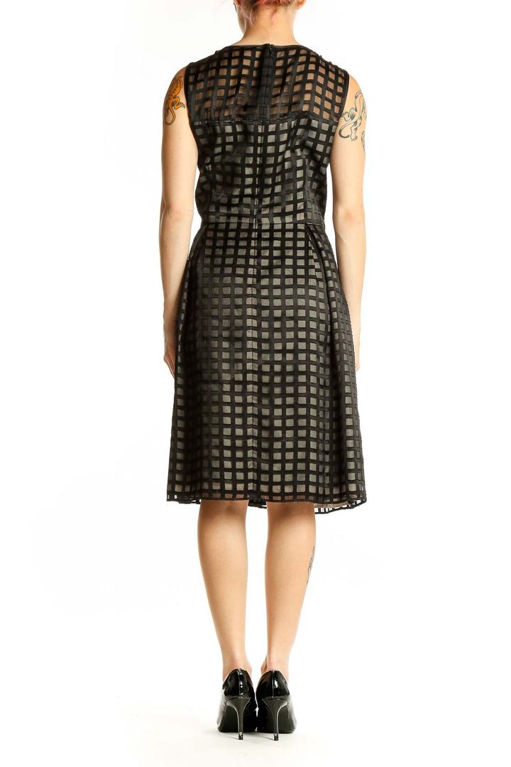Side view of black Calvin Klein cocktail dress showing grid pattern and silhouette