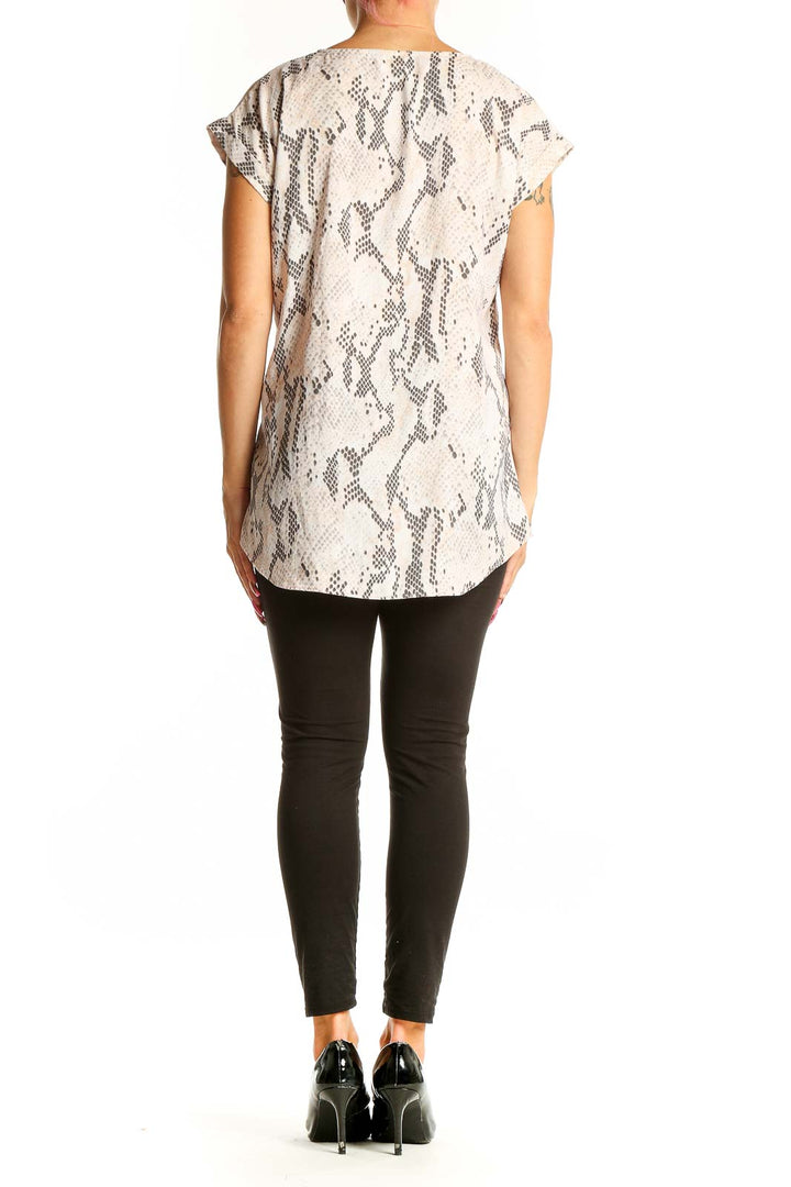 Side view of beige snake print V-neck blouse from Express on model