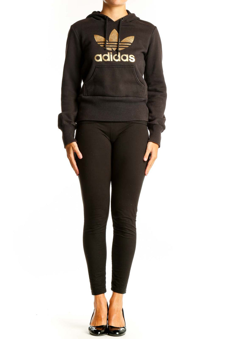 Front view of black Adidas hoodie with gold Trefoil logo