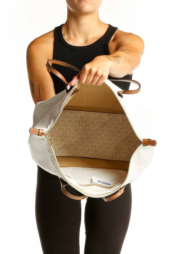 Side view of woman carrying Michael Kors white and yellow striped tote bag