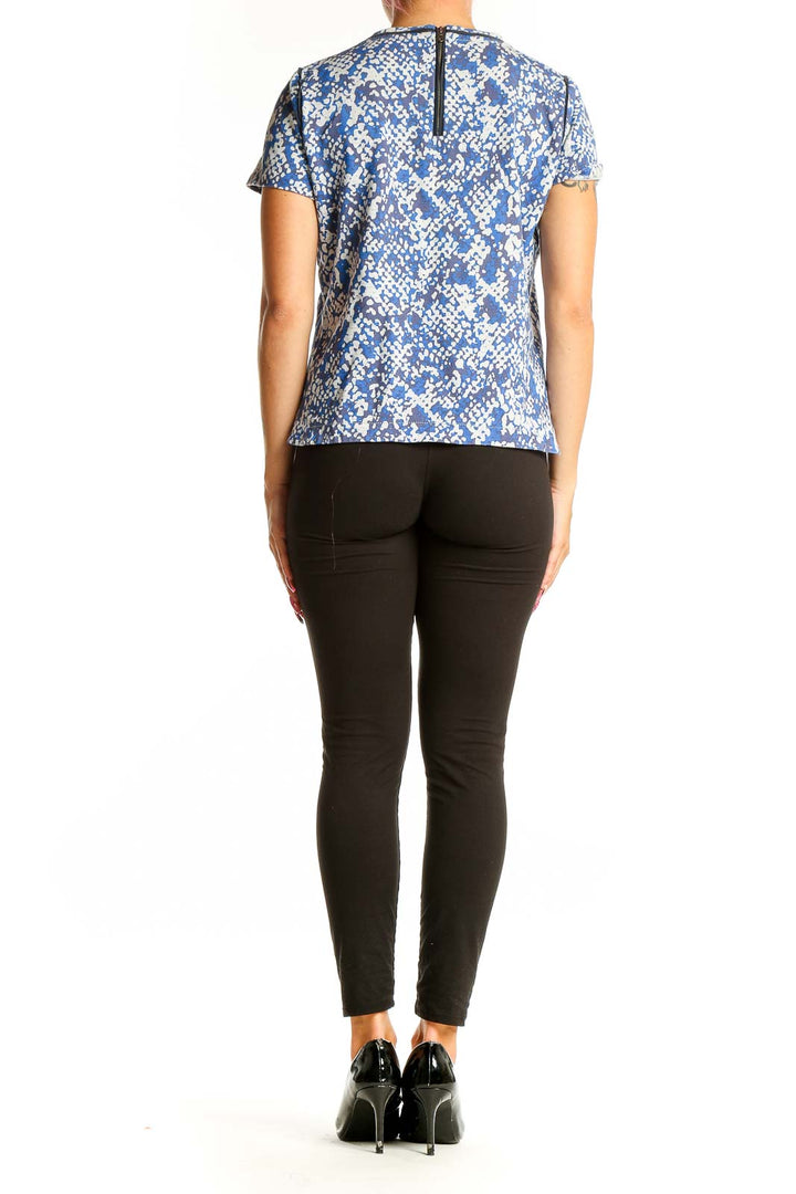 Back view of Club Monaco blue floral print short-sleeve top on model with black pants