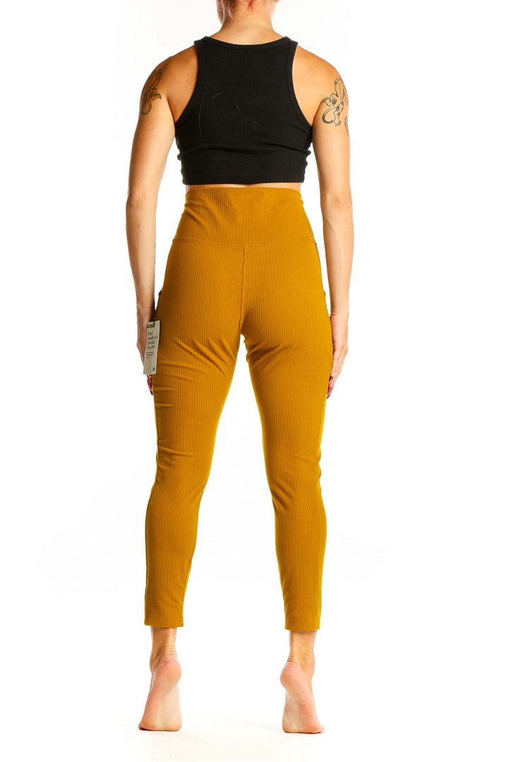 Side view of woman wearing mustard ribbed high-waist activewear leggings